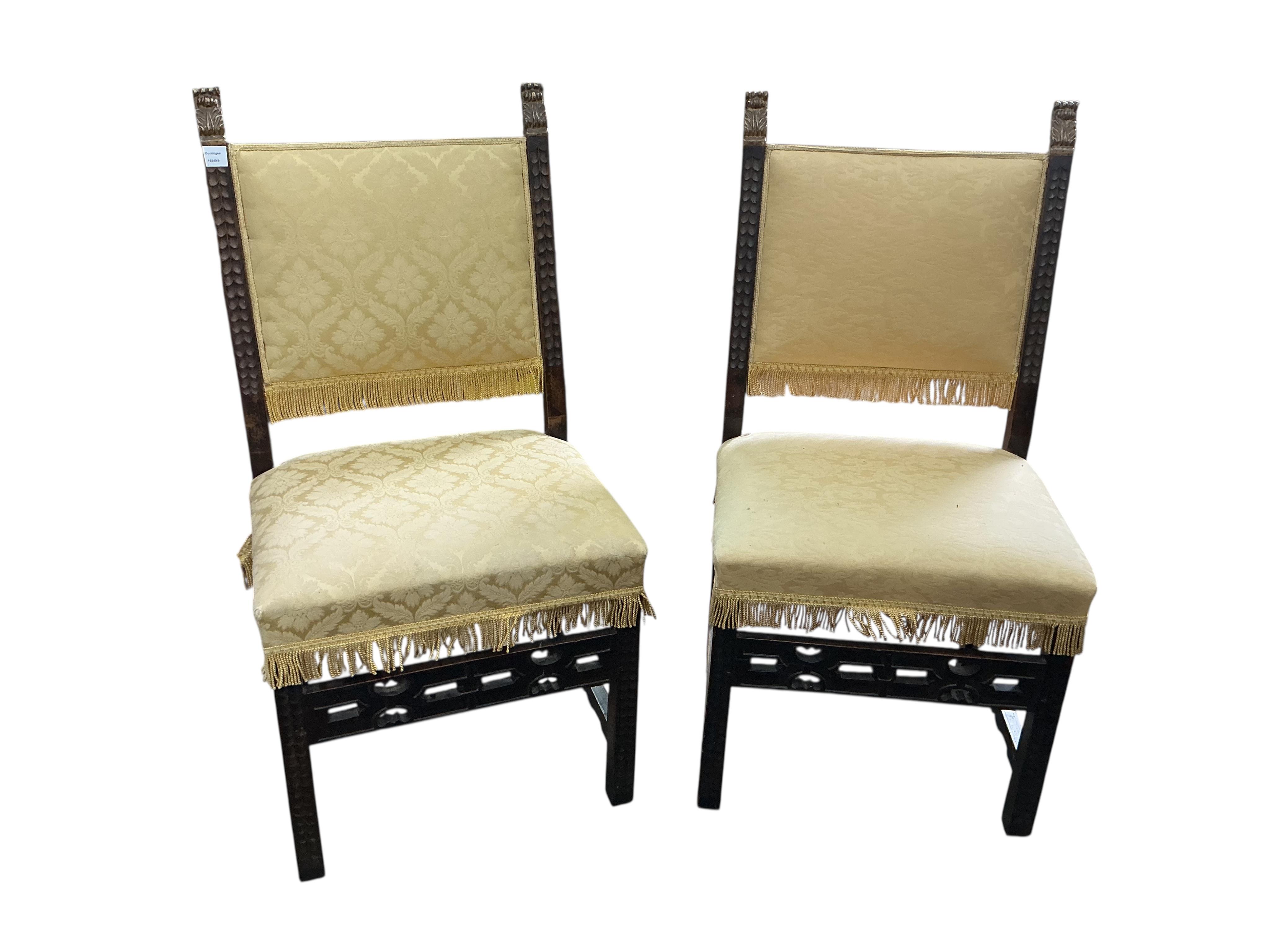 A pair of Italian side chairs carved with foliate bands, parcel gilt terminals and fretwork stretcher, upholstered in yellow damask, width 58cm, depth 48cm, height 118cm